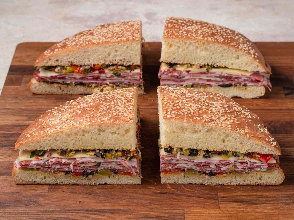 Muffuletta sandwich with salami, ham, cheese and olives on sesame bread